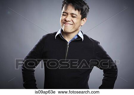 Stock Image - Portrait of mid adult man with eyes closed. Fotosearch
