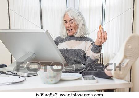Portrait of senior woman sitting at computer with foot on desk View Large Photo Image Stock Image - Portrait of senior woman sitting at computer with foot on desk. Fotosearch