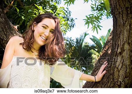 Stock Photo - Portrait of teenage girl climbing tree. Fotosearch