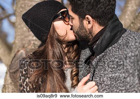 Stock Photo - Portrait of young couple kissing. Fotosearch