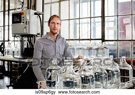 Portrait of young male vodka distiller and demijohns in distillery workshop View Large Photo Image Stock Photo - Portrait of young male vodka distiller and demijohns in distillery workshop. Fotosearch