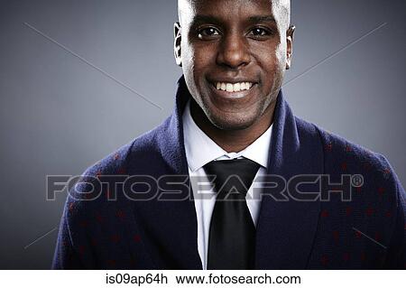 Stock Image - "Portrait of young man, looking at camera, smiling". Fotosearch