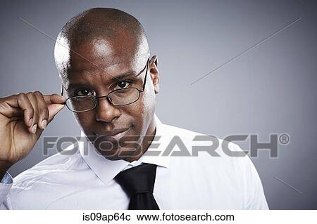Portrait of young man looking over eyeglasses View Large Photo Image Stock Image - Portrait of young man looking over eyeglasses. Fotosearch