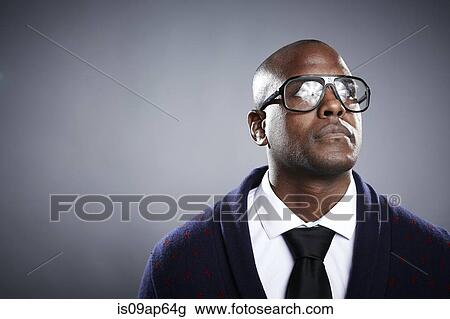Portrait of young man wearing eyeglasses View Large Photo Image Stock Image - Portrait of young man wearing eyeglasses. Fotosearch