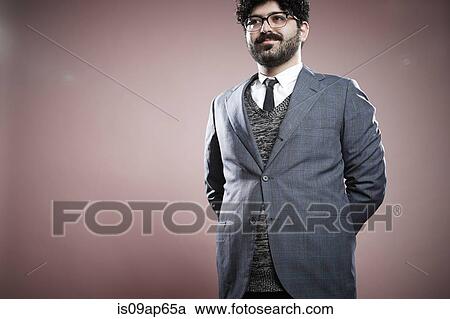 Stock Image - Portrait of young man with hands behind back. Fotosearch
