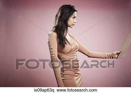 "Portrait of young woman, holding document in front of her" View Large Photo Image Stock Photography - "Portrait of young woman, holding document in front of her". Fotosearch