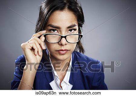 Portrait of young woman looking over eyeglasses View Large Photo Image Picture - Portrait of young woman looking over eyeglasses. Fotosearch