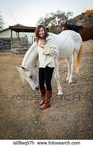 Portrait of young woman petting white horse View Large Photo Image Stock Image - Portrait of young woman petting white horse. Fotosearch