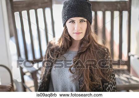 Stock Image - Portrait of young woman wearing knit hat. Fotosearch