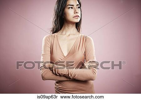 Portrait of young woman with arms crossed and serious expression View Large Photo Image Stock Photography - Portrait of young woman with arms crossed and serious expression. Fotosearch