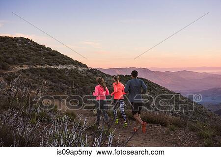 Stock Photo - "Rear view of three adult trail running friends on Pacific Crest Trail, Pine Valley, California, USA". Fotosearch