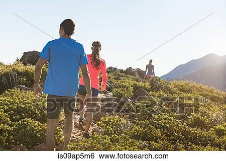 Stock Photograph - "Rear view of three adult trail running friends on Pacific Crest Trail dirt track, Pine Valley, California, USA". Fotosearch