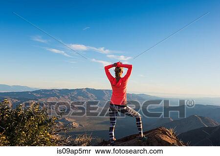 Stock Photography - "Rear view of young female trail runner with hands behind head looking out to view on Pacific Crest Trail, Pine Valley, California, USA". Fotosearch