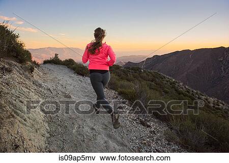 "Rear view of young woman trail running up dirt track at dusk on Pacific Crest Trail, Pine Valley, California, USA" View Large Photo Image Stock Photo - "Rear view of young woman trail running up dirt track at dusk on Pacific Crest Trail, Pine Valley, California, USA". Fotosearch