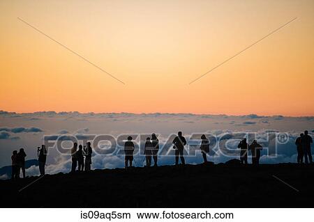 "Row of silhouetted tourists above at sunset, Haleakala National Park, Maui, Hawaii" View Large Photo Image Picture - "Row of silhouetted tourists above at sunset, Haleakala National Park, Maui, Hawaii". Fotosearch