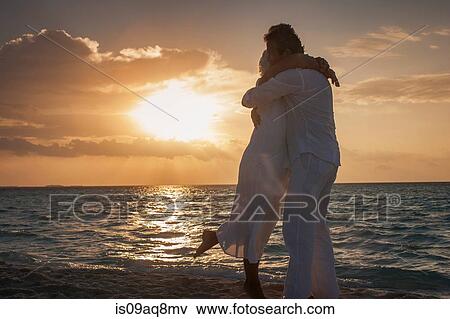 Stock Photo - "Senior couple hugging on beach, Maldives". Fotosearch