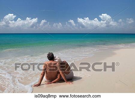 Stock Photography - "Senior couple sitting on beach, Maldives". Fotosearch