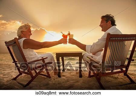 "Senior couple toasting drinks on beach, Maldives" View Large Photo Image Stock Photograph - "Senior couple toasting drinks on beach, Maldives". Fotosearch