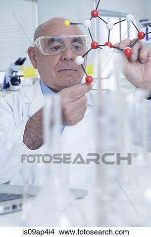 Picture - Senior male scientist holding molecular model. Fotosearch