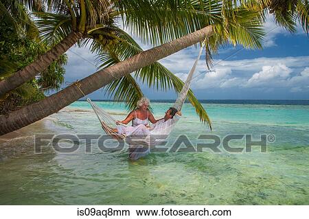 "Senior man relaxing in hammock with woman, Maldives" View Large Photo Image Picture - "Senior man relaxing in hammock with woman, Maldives". Fotosearch
