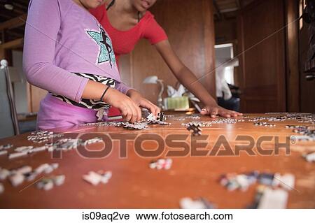 Sisters doing a puzzle on summer vacation View Large Photo Image Stock Image - Sisters doing a puzzle on summer vacation. Fotosearch