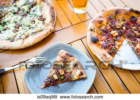 Stock Photograph - Slice of fresh pizza on restaurant table. Fotosearch