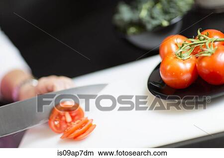 "Slicing tomatoes, focus on knife and tomatoes" View Large Photo Image Picture - "Slicing tomatoes, focus on knife and tomatoes". Fotosearch