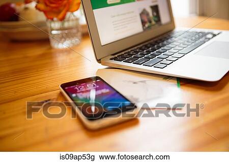 Smartphone and laptop on kitchen table View Large Photo Image Stock Image - Smartphone and laptop on kitchen table. Fotosearch