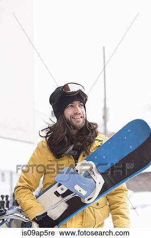 Smiling male snowboarder carrying snowboard in street View Large Photo Image Stock Image - Smiling male snowboarder carrying snowboard in street. Fotosearch