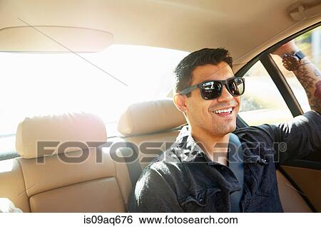 Stock Photograph - Smiling young man in back seat of car. Fotosearch