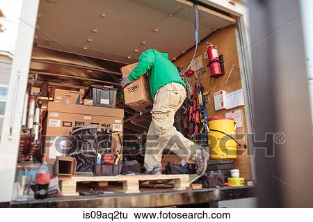 Stock Photograph - Solar panel installation crew member in truck. Fotosearch