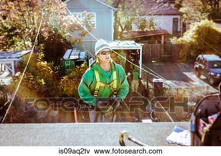 Stock Photo - Solar panel installation crew member coming up to roof. Fotosearch