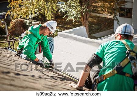 Solar panel installation crew members on roof of house View Large Photo Image Stock Photo - Solar panel installation crew members on roof of house. Fotosearch