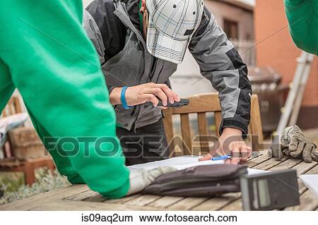 Solar panel installation worker photographing paperwork with phone View Large Photo Image Picture - Solar panel installation worker photographing paperwork with phone. Fotosearch