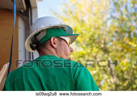 Stock Photo - "Solar panel installation worker, rear view". Fotosearch