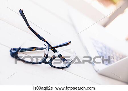 Spectacles and laptop on porch table View Large Photo Image Stock Image - Spectacles and laptop on porch table. Fotosearch