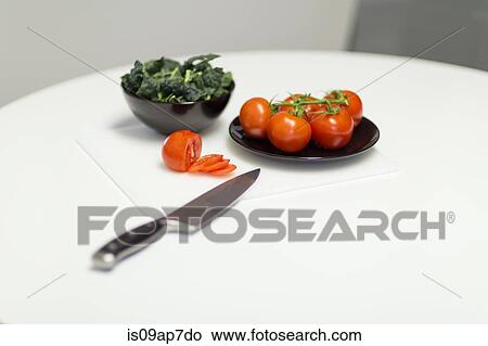 "Still life of tomatoes, kale and knife on table" View Large Photo Image Picture - "Still life of tomatoes, kale and knife on table". Fotosearch