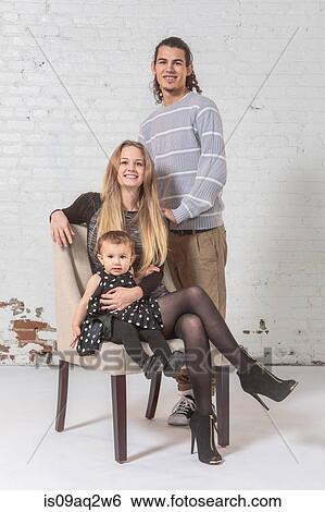 Studio portrait of a young family View Large Photo Image Stock Photograph - Studio portrait of a young family. Fotosearch