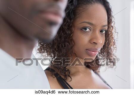 Studio portrait of confident young woman next to boyfriend View Large Photo Image Stock Photograph - Studio portrait of confident young woman next to boyfriend. Fotosearch