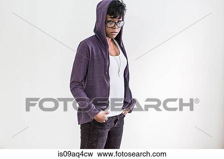 Stock Photo - Studio portrait of young woman wearing hoody. Fotosearch