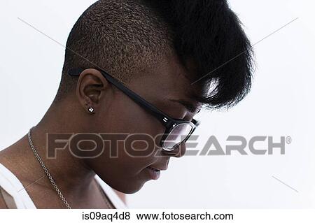 Stock Photo - Studio profile portrait of young woman with shaved head and quiff. Fotosearch