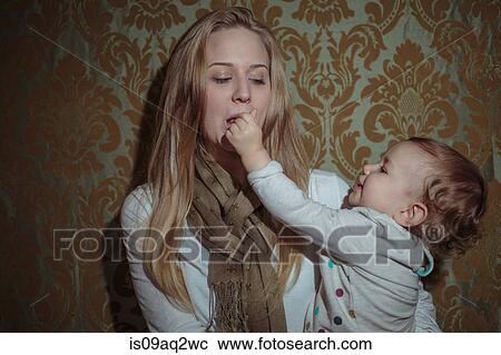 Toddler girl reaching for mother's mouth View Large Photo Image Stock Image - Toddler girl reaching for mother's mouth. Fotosearch