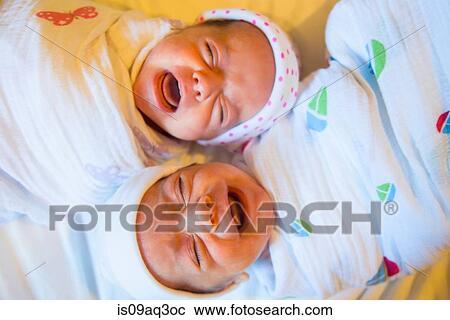 Stock Image - Twin baby sister and brother crying. Fotosearch