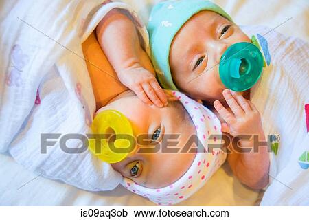 Twin baby sister and brother sucking on comforter View Large Photo Image Stock Image - Twin baby sister and brother sucking on comforter. Fotosearch