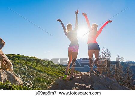 "Two female trail running friends celebrating on rock on Pacific Crest Trail, Pine Valley, California, USA" View Large Photo Image Stock Photo - "Two female trail running friends celebrating on rock on Pacific Crest Trail, Pine Valley, California, USA". Fotosearch