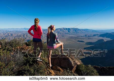 Stock Photography - "Two female trail running friends looking out over landscape on Pacific Crest Trail, Pine Valley, California, USA". Fotosearch