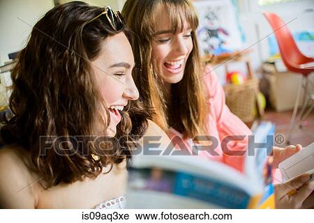 Two young female friends browsing and laughing at books View Large Photo Image Stock Image - Two young female friends browsing and laughing at books. Fotosearch