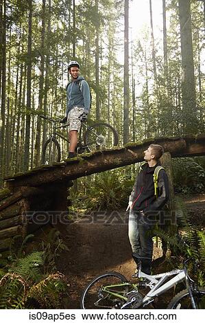 "Two young men with mountain bikes, in forest" View Large Photo Image Stock Photograph - "Two young men with mountain bikes, in forest". Fotosearch