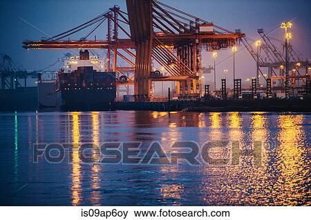 "View of cargo ship and gantry cranes in harbor at night, Tacoma, Washington, USA" View Large Photo Image Stock Photo - "View of cargo ship and gantry cranes in harbor at night, Tacoma, Washington, USA". Fotosearch