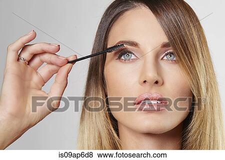 Stock Photo - Woman applying mascara. Fotosearch